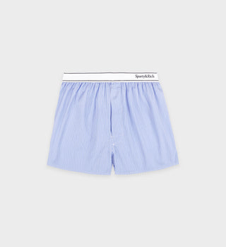 The Serif Logo Boxer Short in light blue and white stripes, featuring an elastic waistband, is made in Portugal by Sporty & Rich and shown on a gray background.