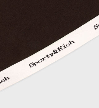 Close-up of the Serif Logo Knitted Cropped Tank in Chocolate/Off White, showing brown cotton-blend fabric with a white edge and black logo text for a sporty, stylish look.