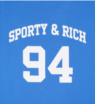 The SR 94 Sports Tee - Blue/White features a blue garment-dyed design with bold white SPORTY & RICH text above the number 94, inspired by classic sports tees.