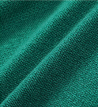 Close-up of the SRC Cashmere Polo - Green in a regular fit, highlighting its textured cashmere fabric and distinctive diagonal folds.