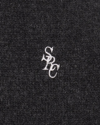 Close-up of a textured black fabric with a white logo on a black background