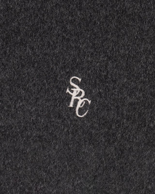 Close-up of a textured black fabric with a white logo in the center.