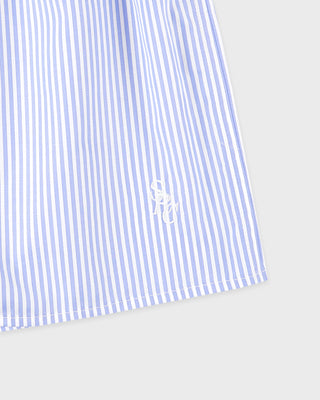 Blue and white striped shirt with a logo on a light gray background