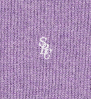 Close-up of the SRC Turtleneck - Eggplant, made from 100% lambswool in a rich purple knit, featuring white embroidered SPC letters at the center.