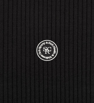 The SRHWC Ribbed T-Shirt - Black features a mock neck collar, ribbed fabric, and a round white patch with Sporty & Rich Wellness Club at the center.