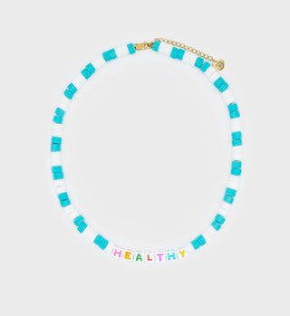 The Healthy Bead Necklace - White/Blue features teal and white beads, multicolor pearls, and colorful letter beads spelling HEALTHY at the center.