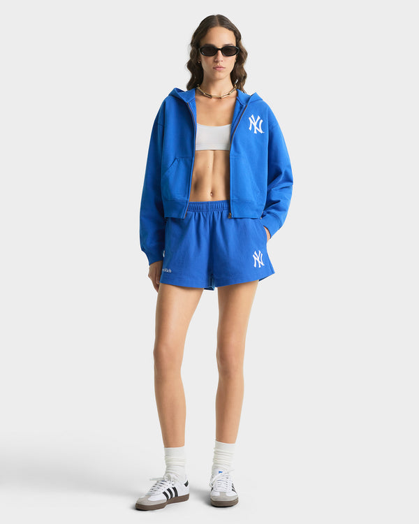 Person wearing a blue tracksuit with a logo on a white background
