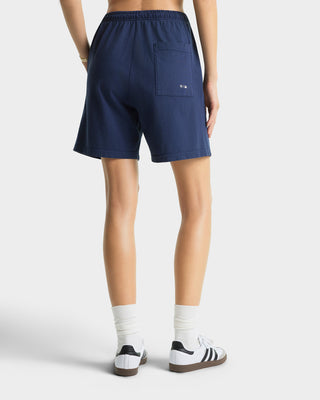 Person wearing navy shorts on a white background