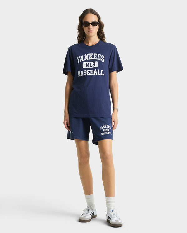 Person wearing a navy 'Yankees Baseball' t-shirt and shorts on a white background