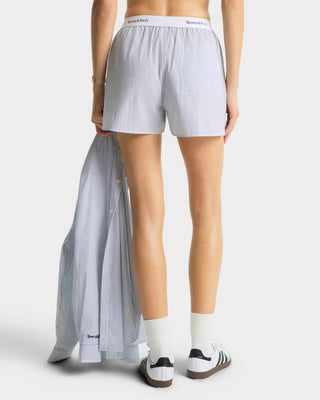 Person wearing striped boxer shorts with a white background