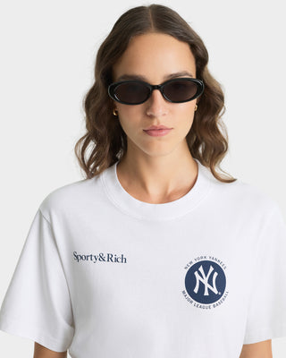 Person wearing a white t-shirt with Sporty&Rich and New York Yankees logos.
