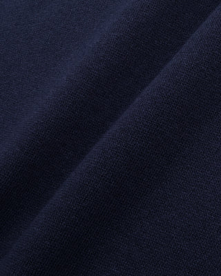 Navy blue hoodie with a brand logo on a light gray background