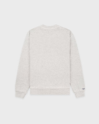 The LA Serif Crewneck in Heather Gray/Navy is a light gray crewneck sweatshirt featuring a classic navy blue LA logo on the left chest. Crafted from 100% cotton, this oversized-fit sweatshirt combines comfort and style, and is showcased against a white background.