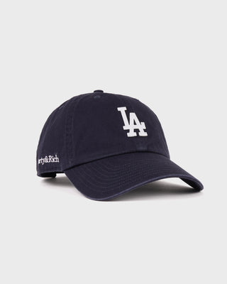 Introducing the LA Hat - Dark Navy/White: a dark navy baseball cap with a white embroidered LA logo on the front, shown against a simple backdrop and designed with an adjustable closure to ensure a comfortable fit.