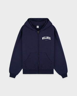 Wellness Ivy Zip Hoodie in Dark Navy/White—crafted in Portugal from 100% cotton, featuring a white WELLNESS print on the left chest and a zip-up hooded design.