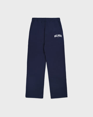 Wellness Ivy Wide Sweatpant in Dark Navy/White, featuring "WELLNESS" text on the left pocket, made from 100% cotton with an elastic waistband, displayed flat on a white background.