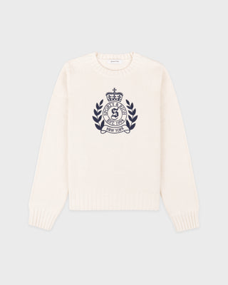 White sweater with a dark emblem on a light gray background
