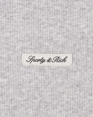 Close-up of a gray textured fabric with 'Sporty & Rich' label.