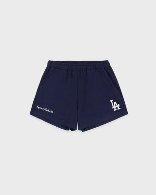 The LA Serif Disco Short in Dark Navy/White is a pair of super-short, cotton fleece shorts featuring Sports&Rich and LA logos on the front, made in the USA and displayed laid flat on a white background.