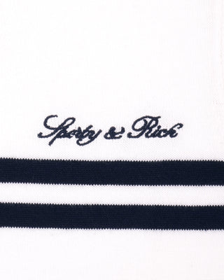 Close-up of a striped fabric with 'Sporty & Rich' branding on a white background
