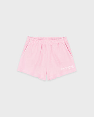 The Fitness 94 Disco Short in Laffy/White features light pink cotton fleece, an elastic waistband, and a Sporty & Rich logo on the bottom right leg. Made in the USA, it is displayed on a gray background.
