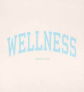 The Wellness Ivy T-Shirt - Cream/Jade features WELLNESS in large blue letters with Sporty & Rich below on a light background. Made in the USA from 100% cotton for comfort and quality.