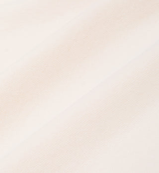 Close-up of soft, light beige 100% cotton fabric with diagonal weave and gentle shadows, featured in the Wellness Ivy T-Shirt - Cream/Jade.