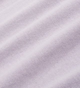 Close-up of faded lilac cotton fabric with visible weave and soft diagonal shadows, made from 100% USA-grown cotton. Featured in the Wellness Ivy T-Shirt - Faded Lilac/White, crafted in Los Angeles.