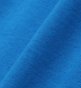 Close-up of vibrant royal blue 100% cotton fabric with visible knit texture and a diagonal fold, featured in our Wellness Ivy T-Shirt - Royal Blue/White.