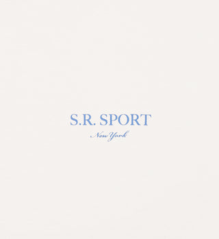 Centered light blue text reads S.R. SPORT New York on an off-white background, featuring the Wimbledon Crewneck - Milk/Washed Hydrangea, made from 100% USA grown cotton.