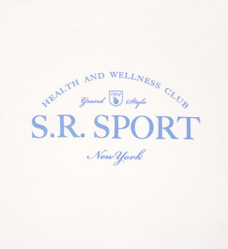 Blue text on a white background reads: S.R. SPORT New York, Health and Wellness Club, Grand Style, 1991. The Wimbledon Crewneck - Milk/Washed Hydrangea is crafted from 100% USA-grown cotton in a classic fit.
