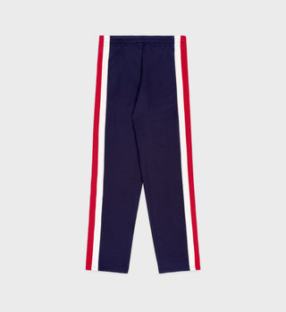 Navy blue pants with red side stripes on a light gray background