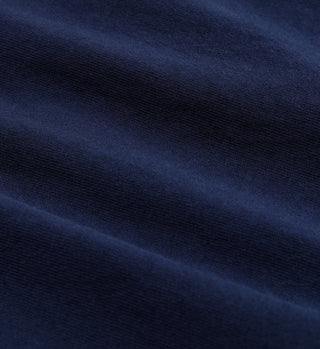 Close-up of dark blue fabric with soft, horizontal folds and a smooth texture—crafted from 100% USA grown cotton, as featured in our Yatch Club T-Shirt - Navy/White.