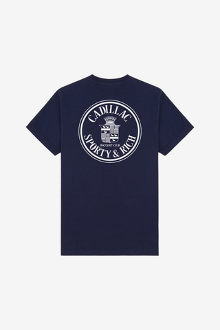 Cadillac x Sporty & Rich Atlas Tee in navy blue, crafted from USA-grown cotton, features a small white circular logo on the left chest and is shown on a white background.