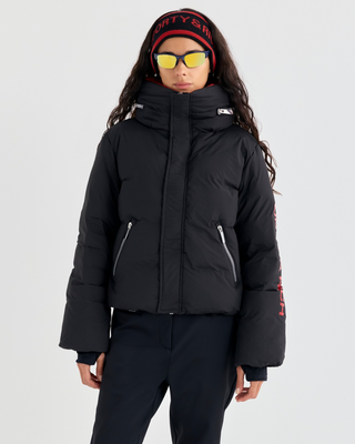 Drea Bold Logo Ski Jacket in black with an oversized fit, red interior collar, and red sleeve text.
