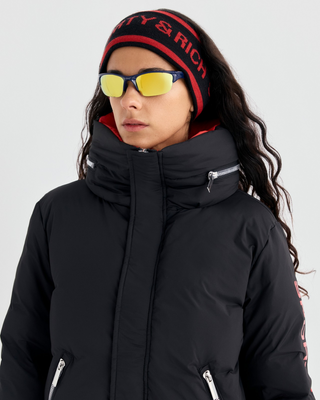 Drea Bold Logo Ski Jacket in black with an oversized fit, red interior collar, and red sleeve text.