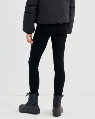 Badir Bold Logo Alpine Legging in black, featuring a high waist, red side stripe, and red text on the waistband.