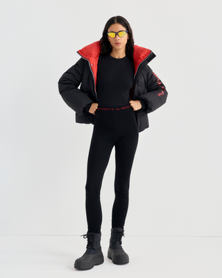 Drea Bold Logo Ski Jacket in black with an oversized fit, red interior collar, and red sleeve text.