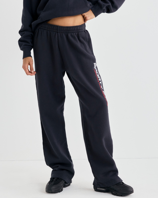 A person in a matching black hoodie and Blakely Bold Health Wide Sweatpant - Black with white lettering.