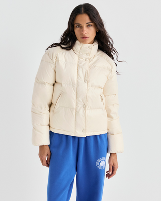 A cream-colored puffer jacket with a stand-up collar and zippered front, displayed on a light gray background.