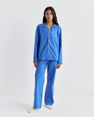 Woman wearing a Cardona Signature Logo Pyjama Shirt in vibrant blue with white piping and a chest pocket.