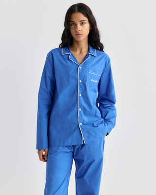 Woman wearing a Cardona Signature Logo Pyjama Shirt in vibrant blue with white piping and a chest pocket.
