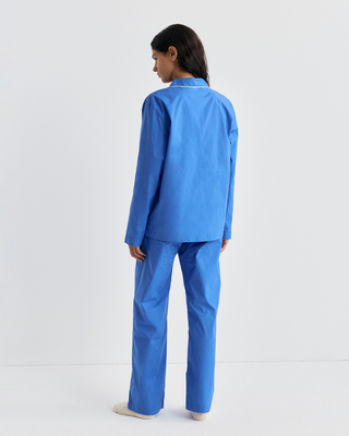 Woman wearing a Cardona Signature Logo Pyjama Shirt in vibrant blue with white piping and a chest pocket.
