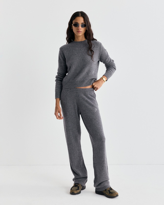 A woman wears a gray cashmere-wool sweater and Ivana S Logo Cashmere Trousers - Medium Heather Gray.