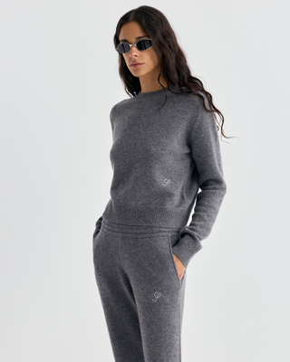 A woman wears a gray cashmere-wool sweater and Ivana S Logo Cashmere Trousers - Medium Heather Gray.
