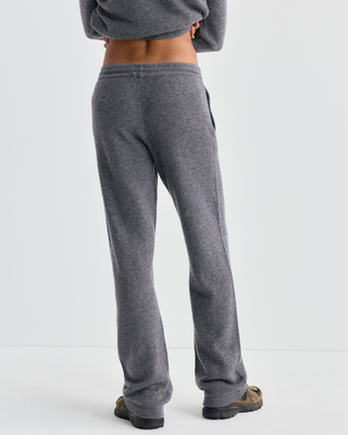 A woman wears a gray cashmere-wool sweater and Ivana S Logo Cashmere Trousers - Medium Heather Gray.