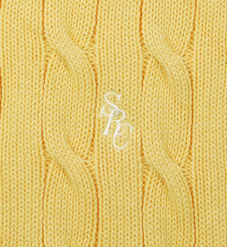 The SRC Cotton Cableknit Sweater in pale yellow features a white embroidered SRC logo centered on soft cotton cableknit fabric.