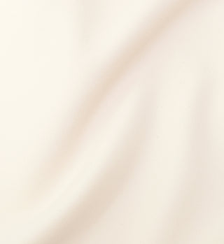 The Classic Logo Cropped Tank - Cream features soft, cream-colored fabric with a smooth texture and gentle drape. A built-in shelf bra offers comfortable support, making it ideal for stylish sportswear or casual lounging.