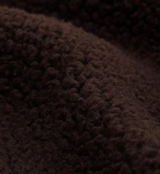 Close-up of the Sherpa Quarter Zip - Chocolate/Cream shows its dark brown, soft fleece with raised, curly fibers—a warm fabric perfect for cozy wear.
