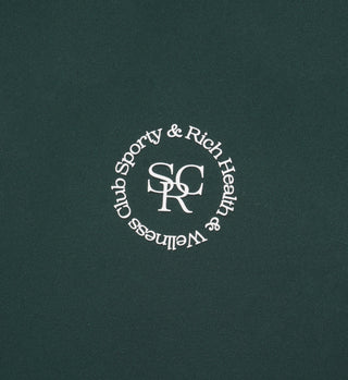 The Sports Bra N.02 - Forest is a dark green bra with a white circular Sporty & Rich Health & Wellness Club logo around S R C, designed for comfort and support.